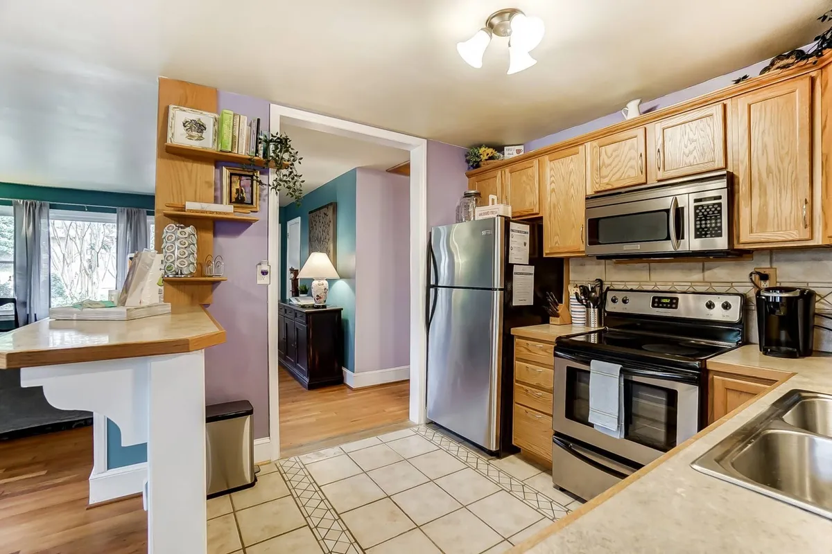 A modern kitchen featuring stainless steel appliances, wooden cabinetry, and an open layout. The space is bright and organized, with plenty of counter space for cooking and entertaining. The warm tones and modern finishes make it inviting for both everyday use and special gatherings.
