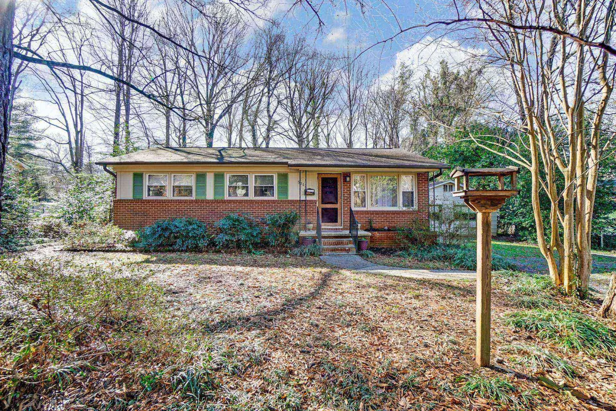 This image presents the inviting front exterior of Dream Catcher’s Bungalow, featuring a welcoming front porch with comfortable seating and a bird feeder overlooking a landscaped garden. The porch is ideal for sipping morning coffee while soaking in the peaceful surroundings, offering a first impression of the home's tranquil and productive atmosphere.